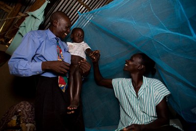 A Kenyan family with their new mosquito net.
