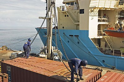 Dock workers handle containers at an African port.