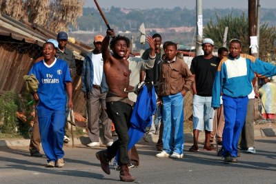 Des habitants de la banlieue de Johannesburg, armes blanches à la main, apparemment très excités pour montrer leur mécontentement