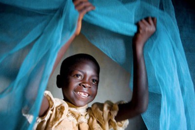 Boy inside a mosquito net.