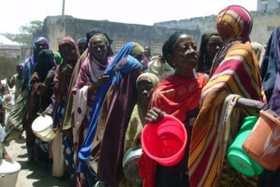Displaced people wait to be given food during a distribution organised by the UN World Food Programme, USAID and other local and international NGOs in Somalia.