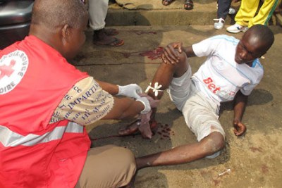 An Ivorian Red Cross volunteer providing first aid to an injured man at the scene of the violence.