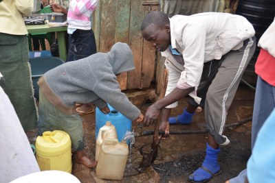 Residents pump water. Filling a 20-litre can with water costs 3 Kenyan shillings. Life Force Kiosks' services aim to address three points where water contamination could occur: chlorine tablets for possible contamination through rusty pipes, jerry cans washed with soap to combat dirty containers, and eventually a third product: closed storage containers so water can't be contaminated in the home through contact.