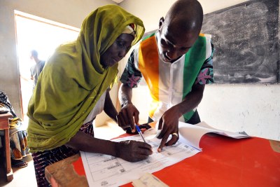 Une femme qui signe un document certifiant son vote dans la localité de Bondoukou.