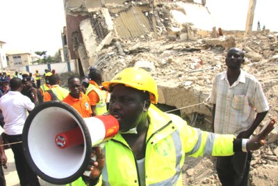 Rescue workers attempt to secure a collapsed building site in Gwarimpa, Abuja.