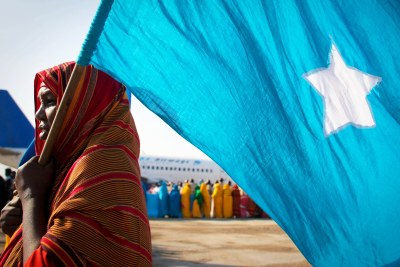 Woman carries the Somali flag.