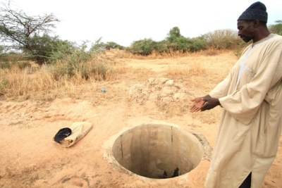 A villager in northern Senegal shows an empty well following poor rains in 2011.