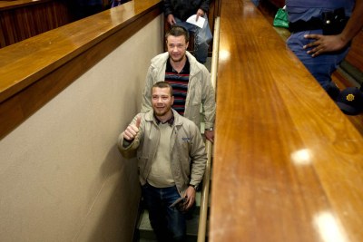 White right-wingers descend to cells under a South African courtroom.
