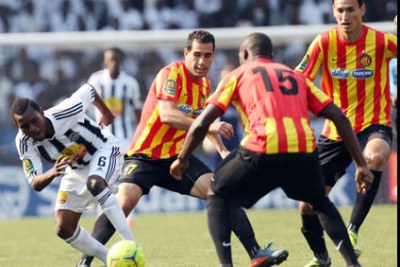 Un joueur de Tp Mazembe (en noir et blanc) pris en tenaille par l'arrière-garde de l'Espérance de Tunis