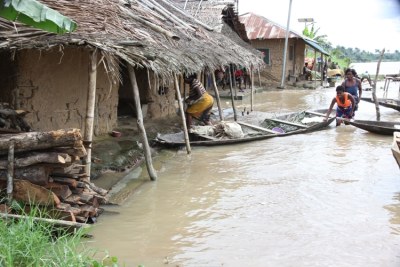 Women with a dug-out canoe in front of their flooded homes in Toru-Orua in Sagbama.