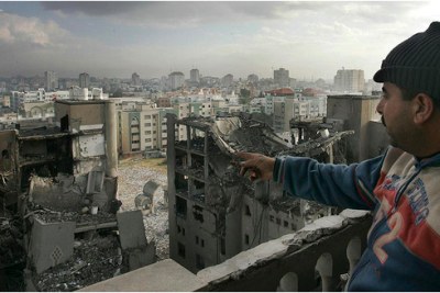 A Palestinian man looks out towards destroyed buildings following an Israeli air strike in Gaza City (file photo).