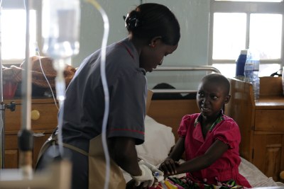 Nurse treating a young patient at the Uganda Cancer Institute.