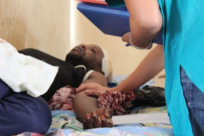 Hôpital de NDosho, Goma. Une infirmière du CICR réconforte un patient souffrant d'une fracture du crâne causée par une blessure par balle. Les chirurgiens du CICR ont opéré pour retirer la balle. (archive)