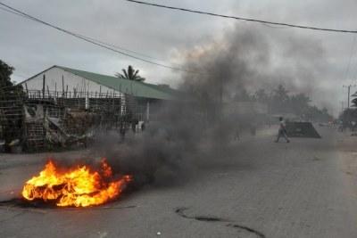 After riot police dispersed a mob from the vicinity of Frelimo's local headquarters, people set up burning barricades to block traffic.