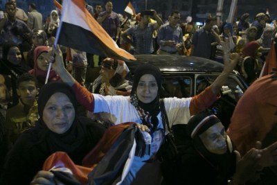 Egyptians wave flags during a rally to celebrate the presidential election in Tahrir Square, Cairo.
