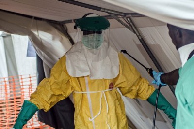 An MSF health worker donning a protective suit to treat Ebola victims in Kailahun, Sierra Leone. July 2014.