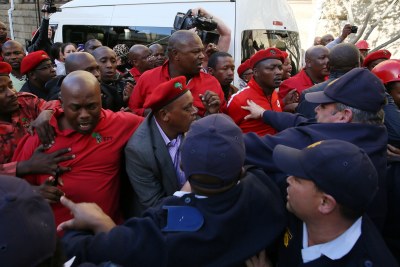 Policemen break up a scuffle between EFF MPs and ANC members at Parliament in Cape Town (file photo)