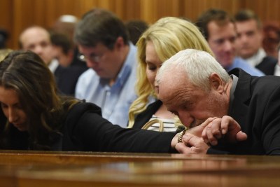 Paralympian Oscar Pistorius's father Henke Pistorius kisses the hand of his daughter Aimee Pistorius while judgment is handed down at the High Court in Pretoria (file photo).