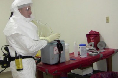 An American soldier in PPE preparing to work on specimen at a mobile lab in Bong County in central Liberia.
