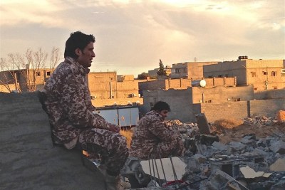 Dusk in the Libyan town of Ben Jawad, where two soldiers from forces operating under the Tripoli-based government sit by the rubble of another flattened home. The front-line, near Es Sidra oil port, is just 30 kilometres away