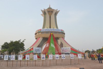 Le monument des martyrs drapé des couleurs nationales. Au premier plan, les portraits des désormais héros nationaux