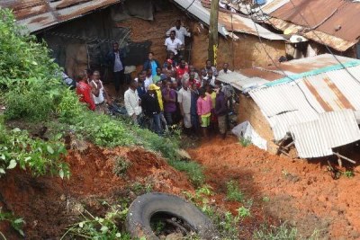 Locals mill around a house which had collapsed and killing one person on spot over ongoing heavy rain at Kalahari Changamwe Mombasa.