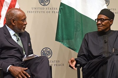 Ambassador Johnnie Carson (left) and Nigerian President Muhammadu Buhari at the U.S. Institute of Peace.