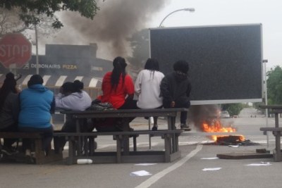 Rhodes students barricade a road and burn tyres in protest of tuition fee increases.