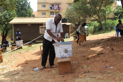 A voter in Mengo, Kampala casts his vote after a grenade exploded there the night before the vote. Police are  investigating the explosion which killed at least 3 people.
