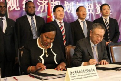 Former Macro-Economic Planning and Investment Promotion Deputy Minister Monica Mutsvangwa (left) and the Deputy Director General of Qingdao Bureau of Commerce Mr Chunyu Xianli (right) sign a MoU for economic co-operation yesterday while officials from both countries look on.