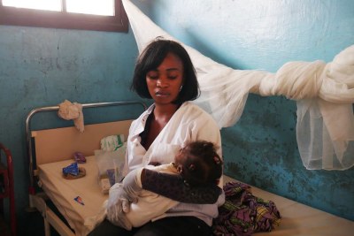 Une infirmière à l’hôpital de Kahemba, en RDC, s’occupe d’un enfant dont la mère, atteinte sans doute de la fièvre jaune, est décédée après être arrivée à l’hôpital.