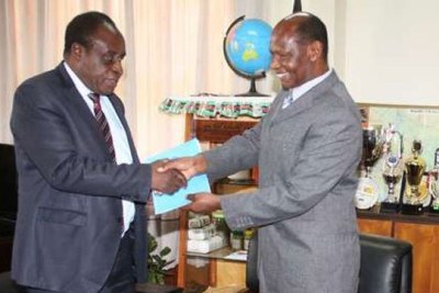 Richard Mibey (right), then vice-chancellor of Moi University, hands over to Laban Ayiro.
