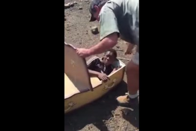 Screenshot from a viral video depicting Victor Mlotshwa being forced in a coffin.