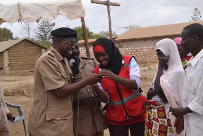 Kilifi County Commissioner Joseph Keter (left) and county Kenya Red Cross manager Hakima Masoud (right) verify an SMS text from one of the beneficiaries of the cash transfer programme launched in Kaloleni.