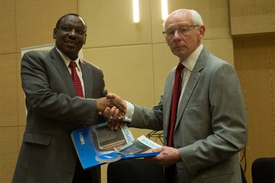 Finance and Economic Planning minister Claver Gatete exchanges documents with I&M Bank board chairperson Bill Irwin during the Initial Public Offering for the bank in Kigali.
