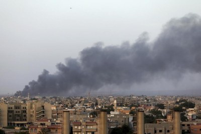 De la fumée s'élève au dessus de la zone de combats entre milices islamistes et troupes du général Khalifa Haftar, non loin de l'aéroport de Benghazi, en Libye, le 23 août 2014.