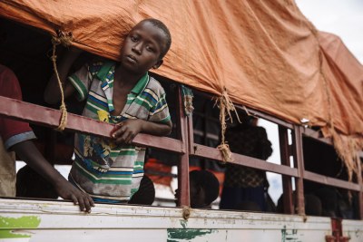 Un jeune réfugié sud-soudanais sort sa tête de l’extérieur d’un camion avant d’être transporté au centre d’accueil d’Imvepi, dans le district d’Arua, au nord de l’Ouganda.