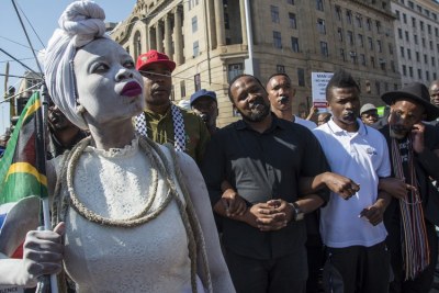 A woman dressed in white led a march in Pretoria on Saturday against violence against women.