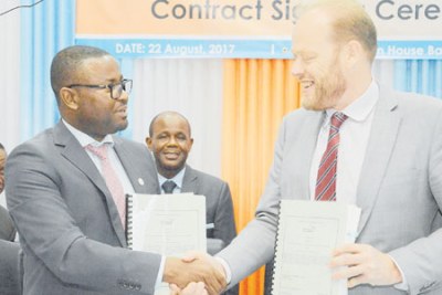 Tanzania Civil Aviation Authority director general Hamza Johari shakes hands with Thales Air Systems regional sales manager Abel Carr after signing an agreement in Dar es Salaam. Looking on is Works, Transport and Communication minister Makame Mbarawa.