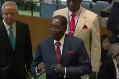 President Robert Mugabe stumbles to the podium.