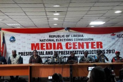 Chairman of the National Elections Commission Jerome G. Korkoya, fourth from left, announces results.