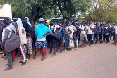 Des hommes expulsés d'Algérie font la queue après leur arrivée à Bamako, le 25 octobre 2017.