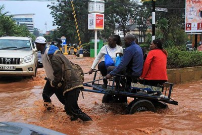 Nairobi residents are taken across a flooded section of Peponi Road last week.
