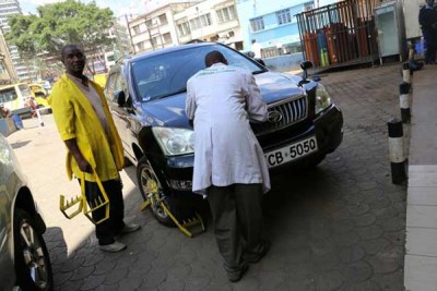 Nairobi City County attendants clamp a car whose owner had not paid for parking (file photo).
