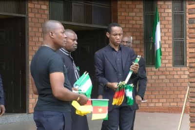 Men hand out flags to people praying for peace in Cameroon's restive English-speaking regions, at Saint Joseph's Anglophone Parish in Cameroon's capital, Yaounde on September 6, 2019.