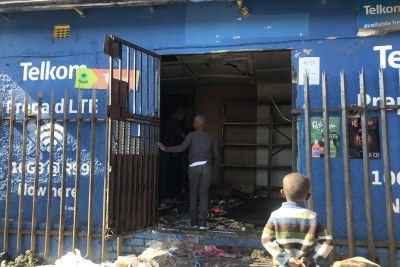 Children stand at the door of a looted shop in Alexandra, Johannesburg.