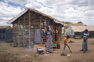 Inês Nambueda, 42 ans, prépare de la nourriture pour sa famille devant son abri inachevé sur le site de personnes déplacées de Lianda. « Ma maison dans mon village est toujours debout, j'étais prête à y retourner, mais en raison de la situation sécuritaire instable, j'ai décidé de venir à Lianda avec ma mère et mes cinq enfants », dit-elle.