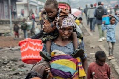 A woman walks through the streets with children in Goma in the eastern Democratic Republic of the Congo..